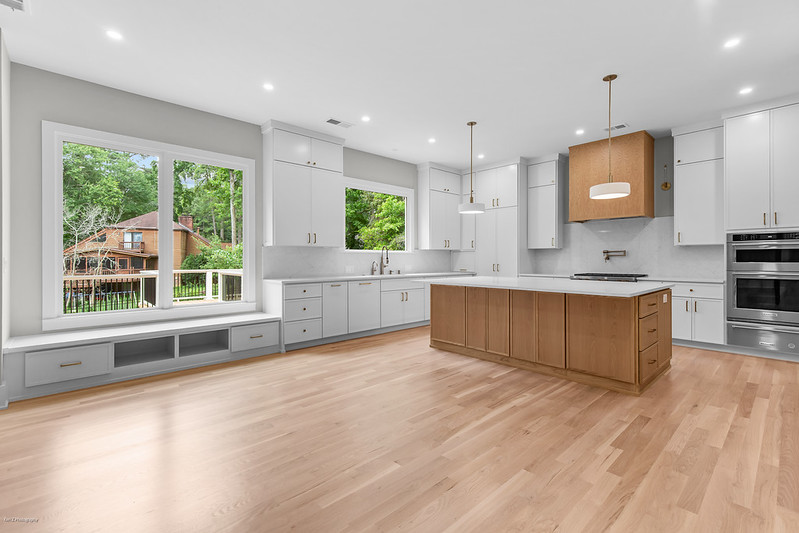 White kitchen with a natural wood island, wood range hood, and window seat, Brookcliff new custom home, Marietta, GA