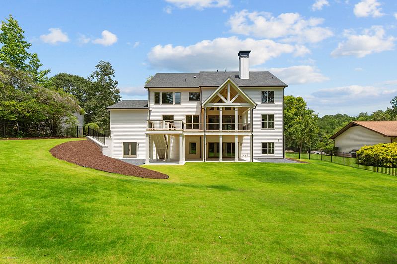 Rear elevation with stacked decks and a stone chimney, Brookcliff new custom home, Marietta, GA