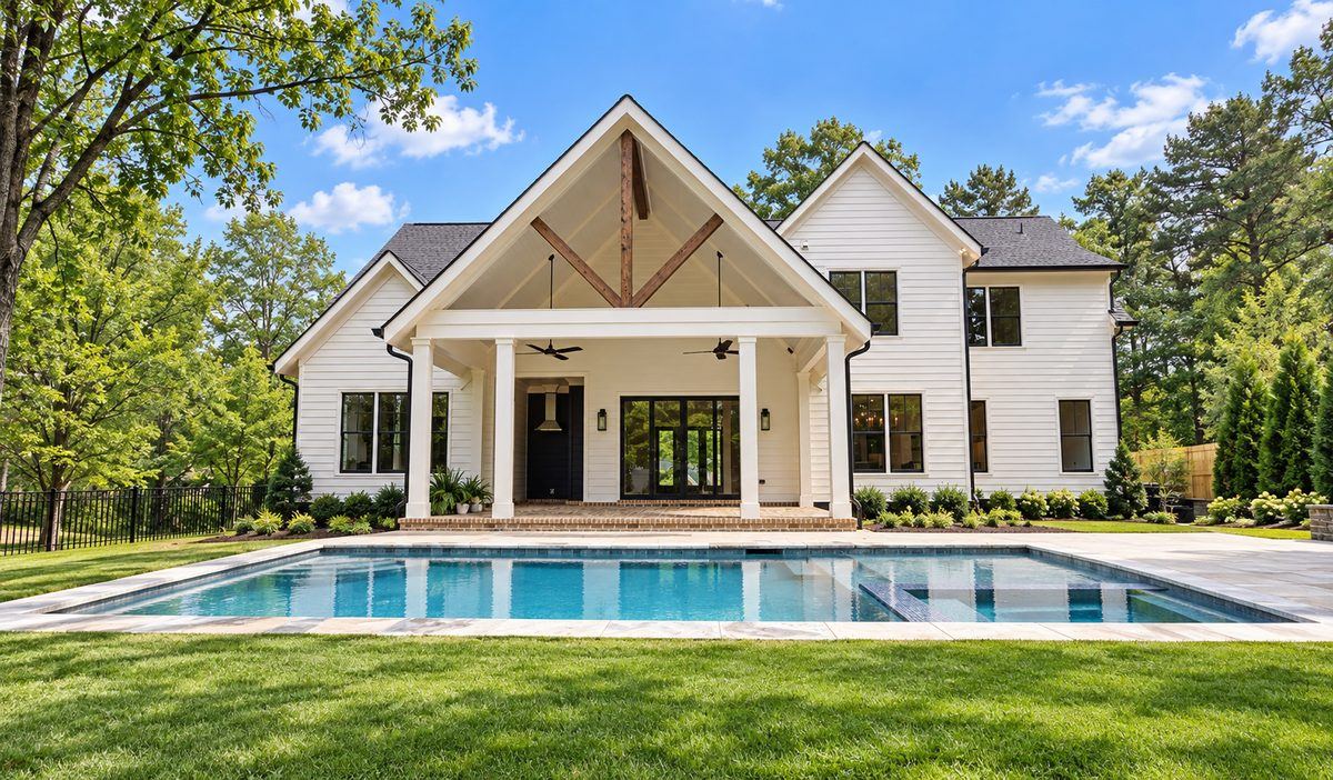 Rear exterior with covered porch and pool at the Penhurst new custom home by GCG Home Builders in Roswell, GA