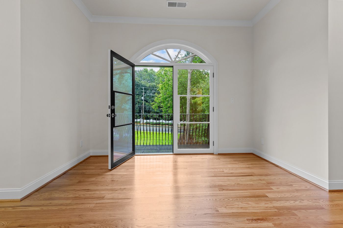 Room with hardwood floors and an arched door to the back yard, Henderson Mill new custom home, DeKalb County, GA