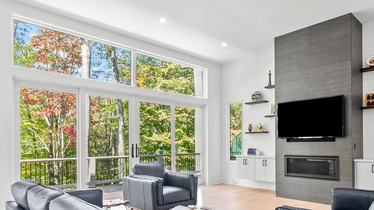 Living room with a two-story wall of windows and a tiled fireplace wall, Old Orchard new custom home, Marietta, GA