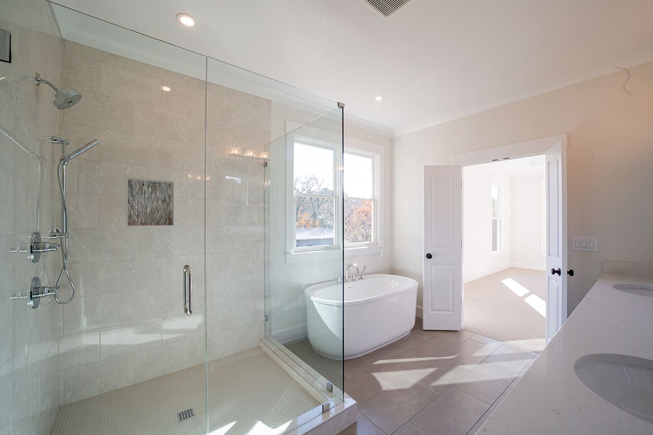 A bathroom with a large glass shower and a tub.