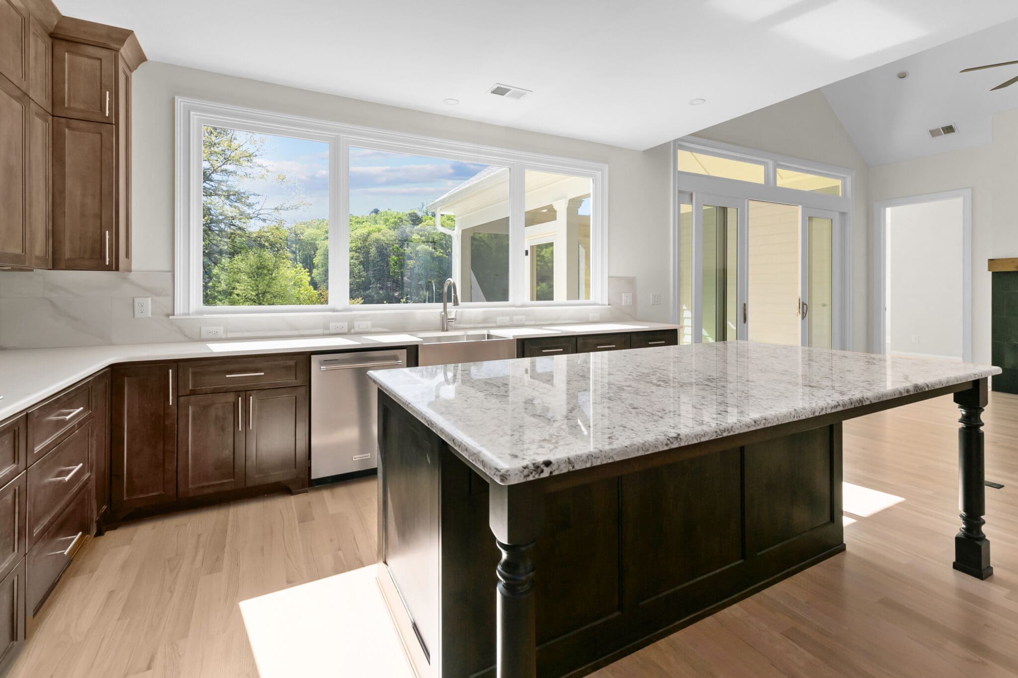 A large kitchen with granite counter tops and wooden cabinets.