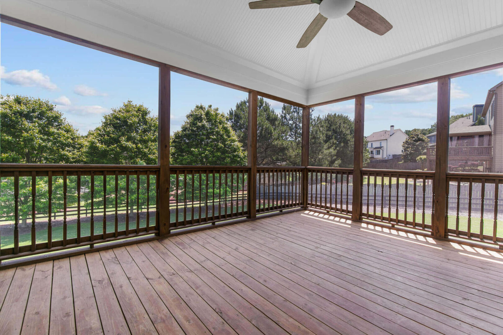 A large open porch with a ceiling fan.