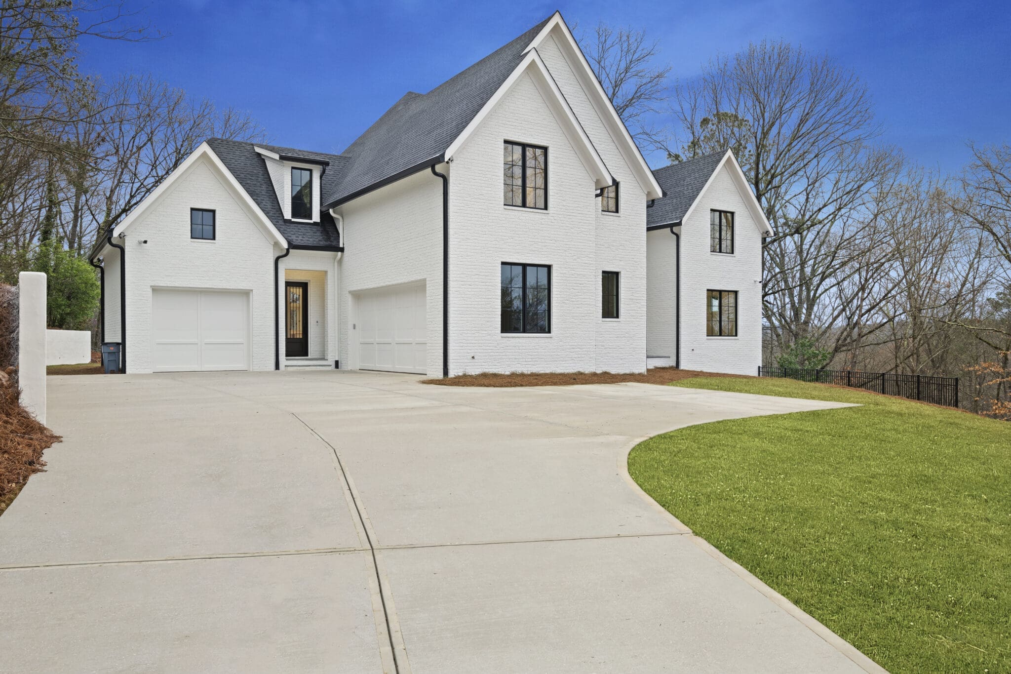 A large white house with a driveway in front of it.