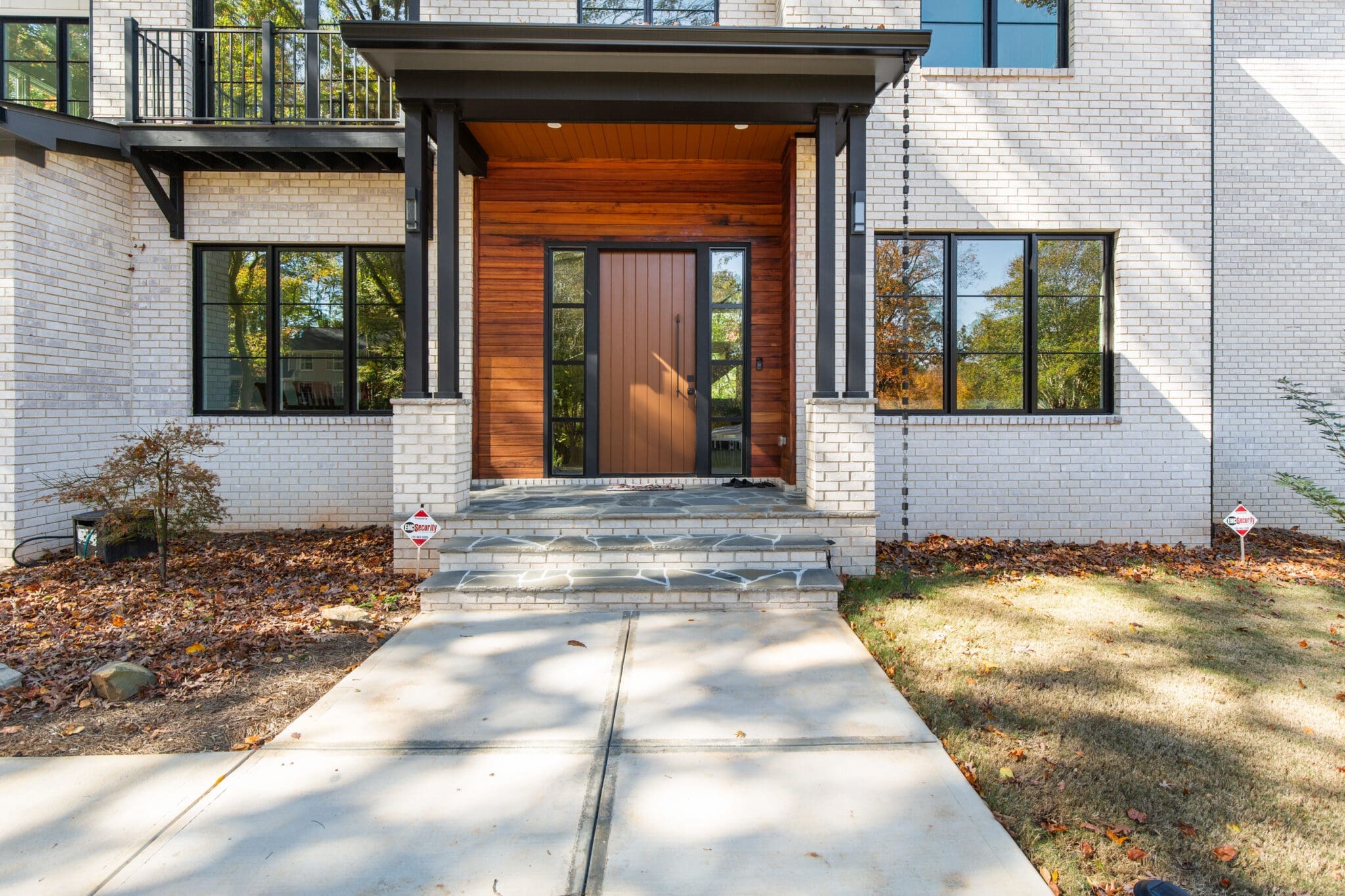 A front door of a house with a concrete walkway.
