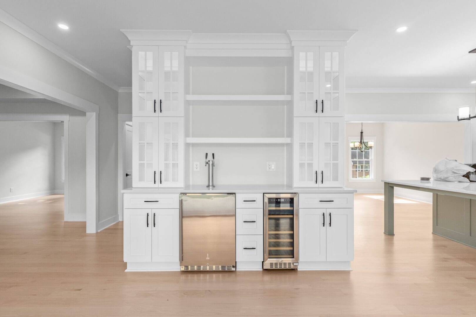 White kitchen bar with built-in fridge and wine cooler.