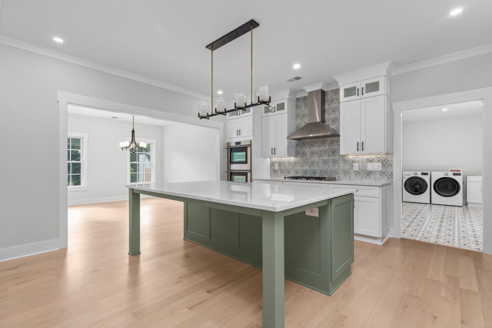 Modern kitchen island with green cabinets.