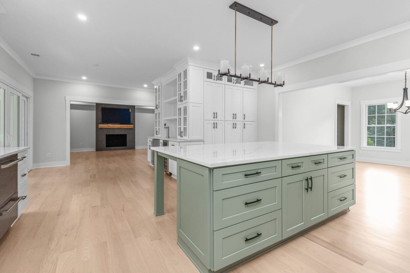 Kitchen island with white countertop and green cabinets.
