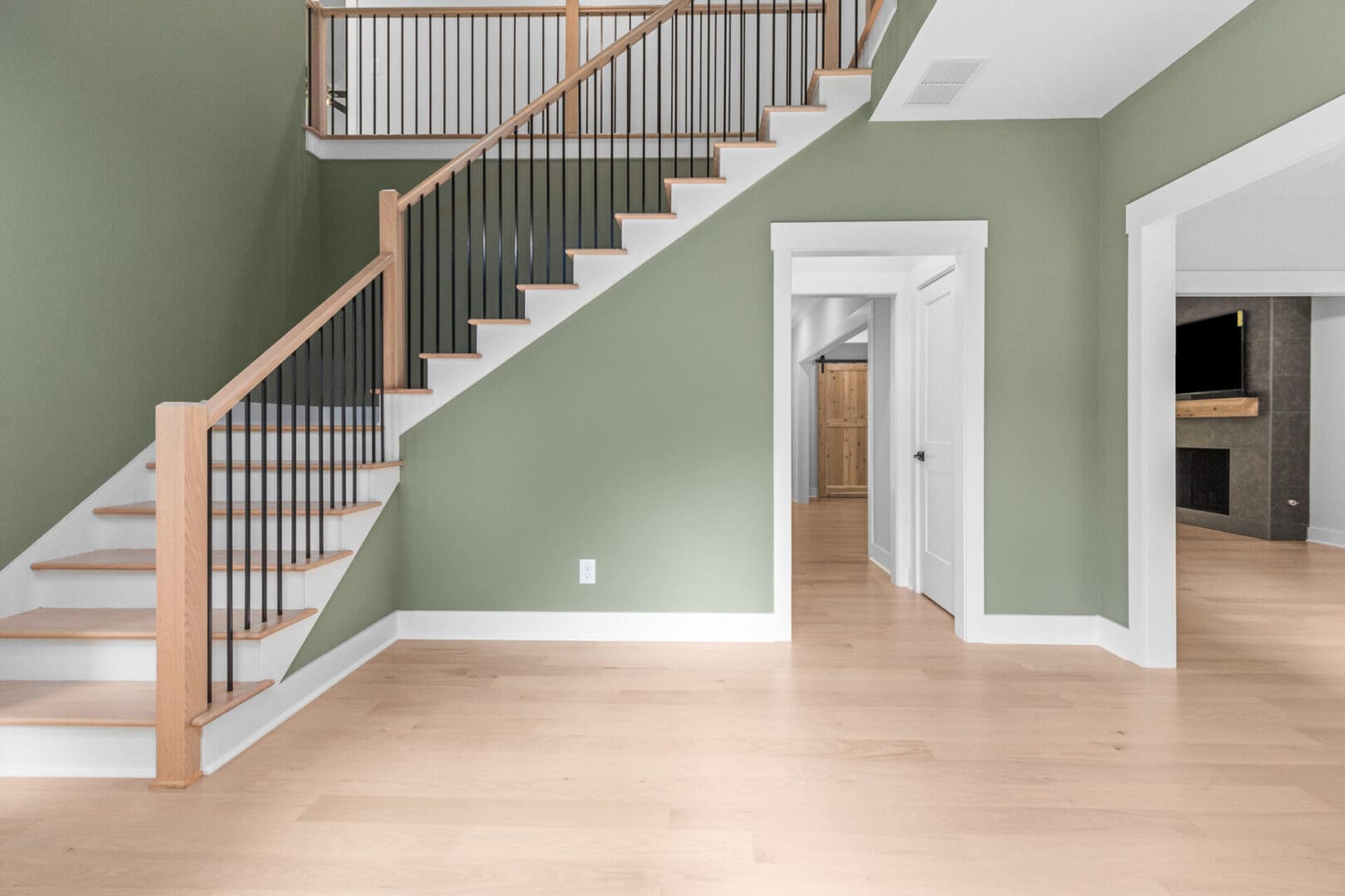 Wood staircase with green walls and white trim.