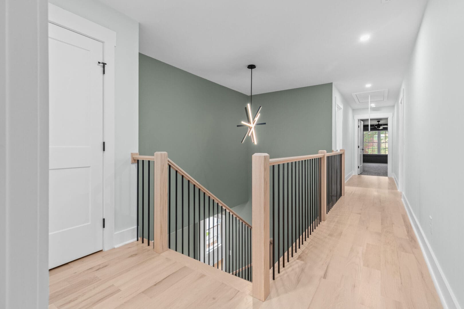 Modern hallway with green wall and stairs.