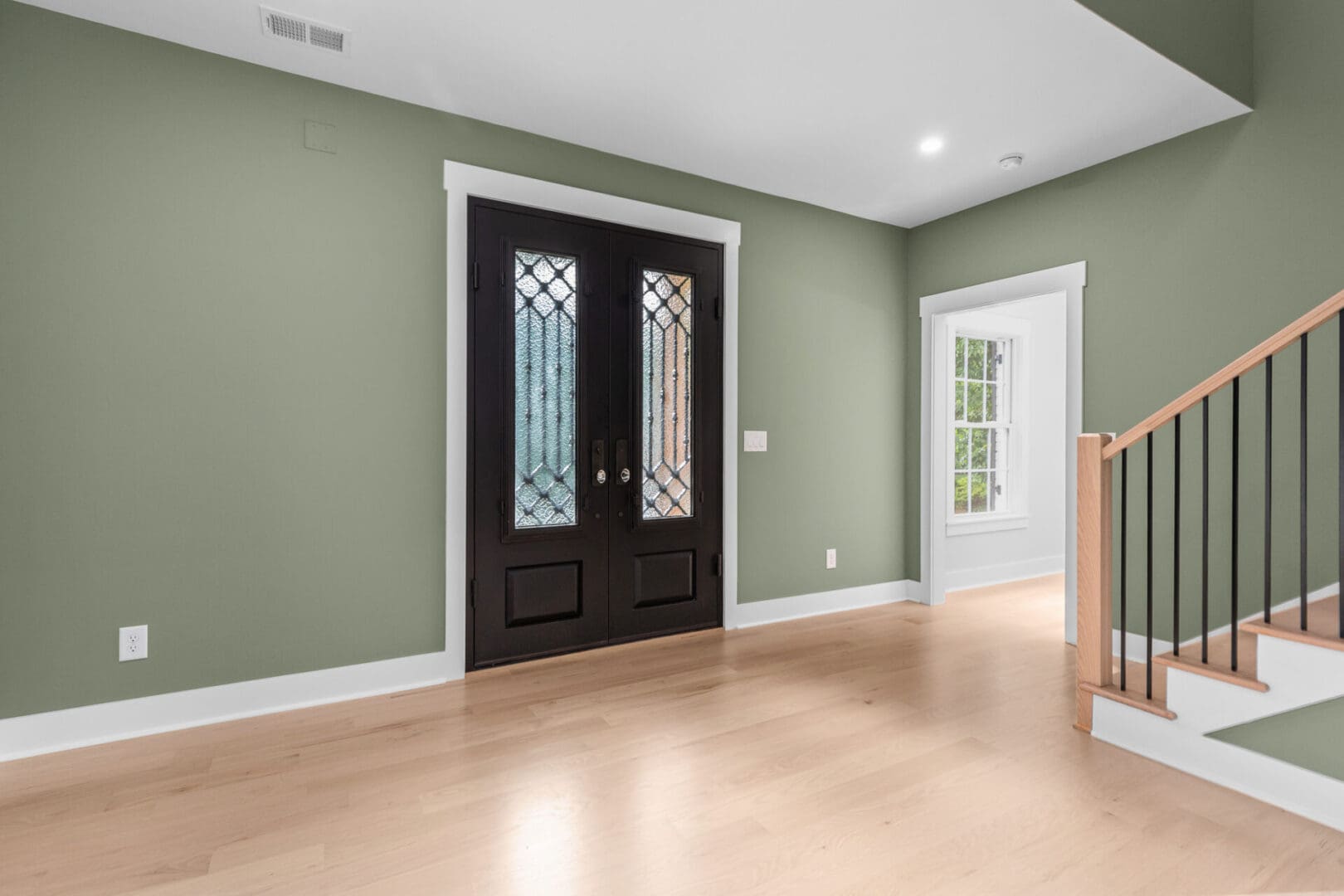 Green walls with double doors and stairs.
