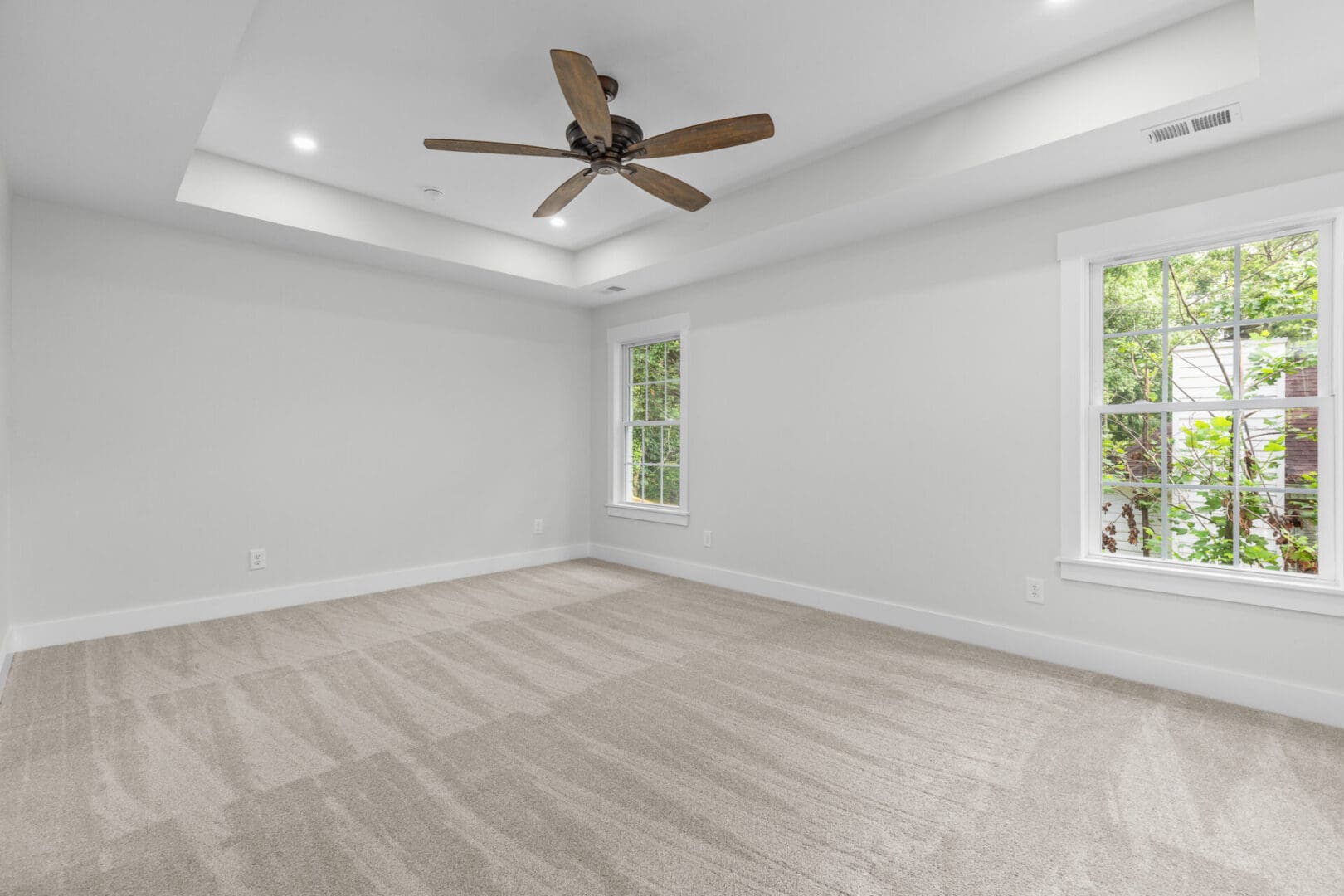 Empty bedroom with carpet and ceiling fan.