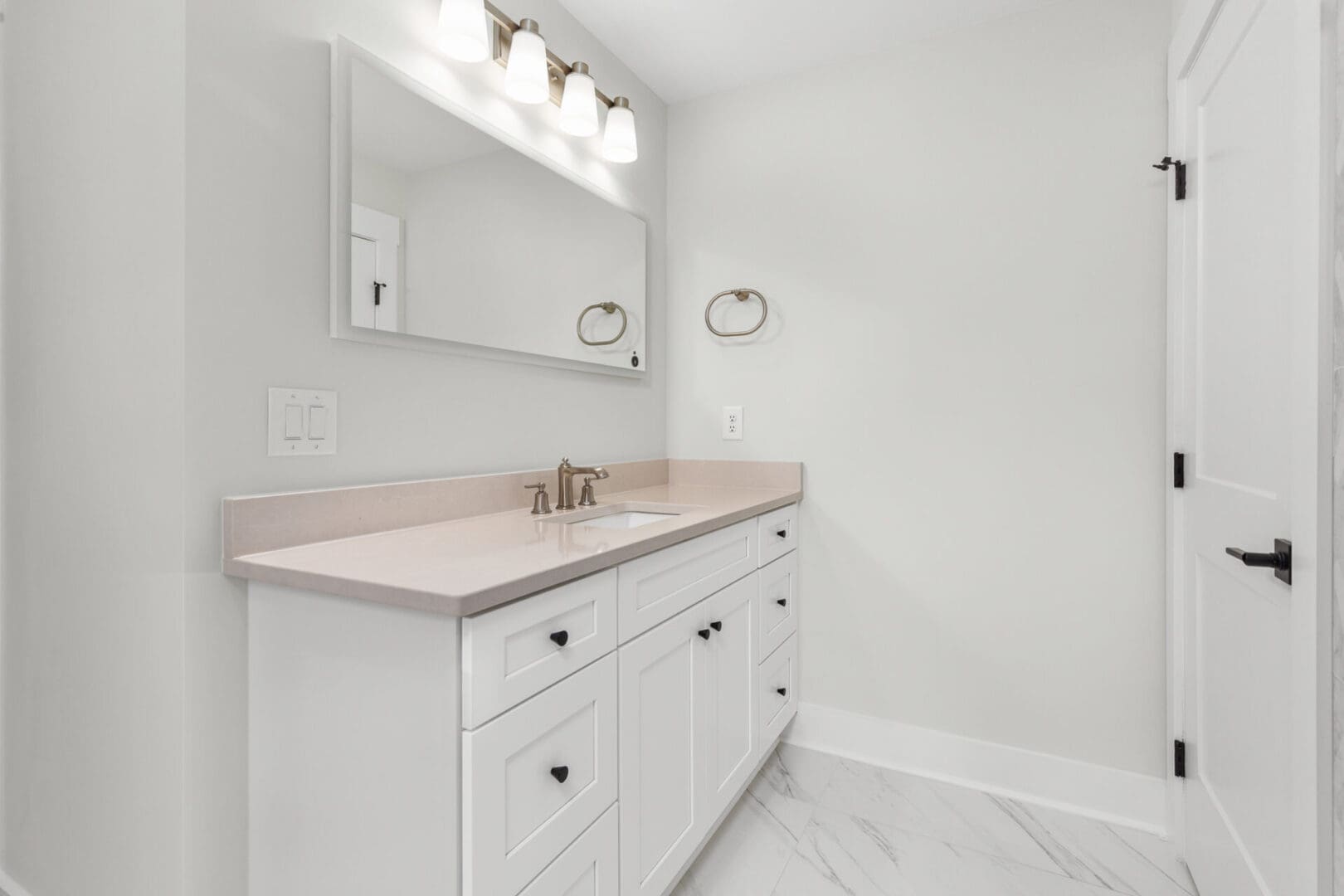 White bathroom vanity with marble floor.