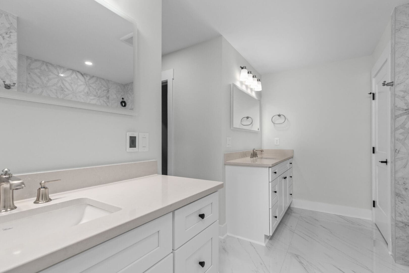 White bathroom with vanity and shower door.