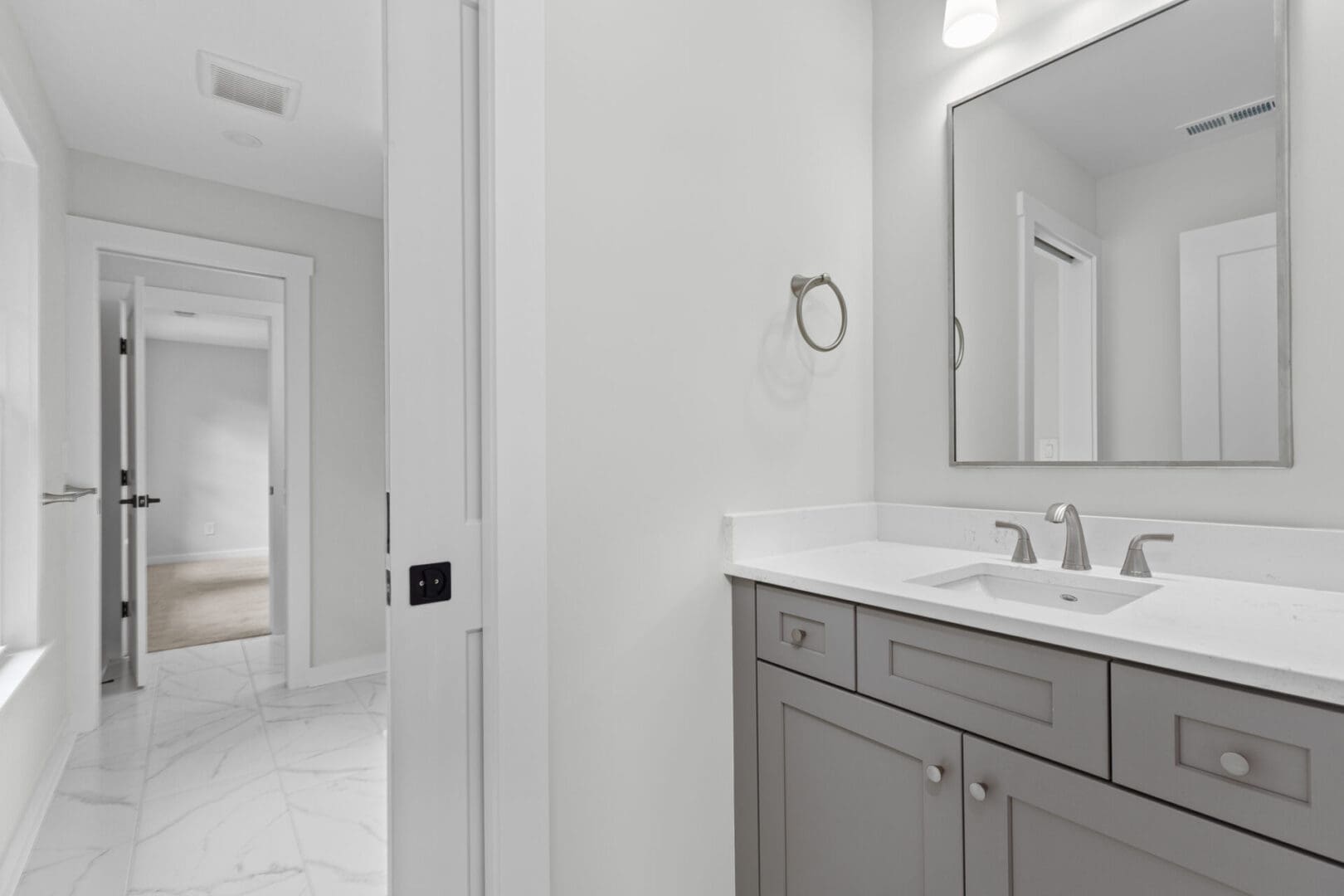 Gray bathroom vanity with white countertop.