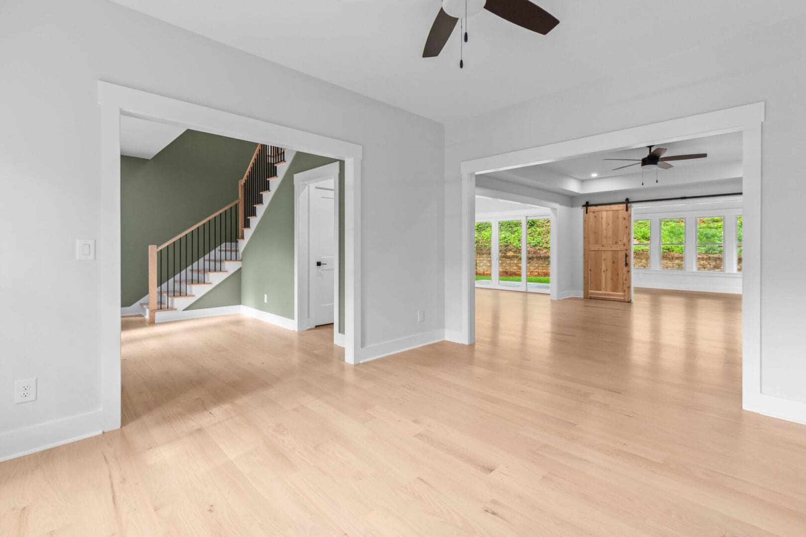 Open floor plan with wooden floors and a staircase.