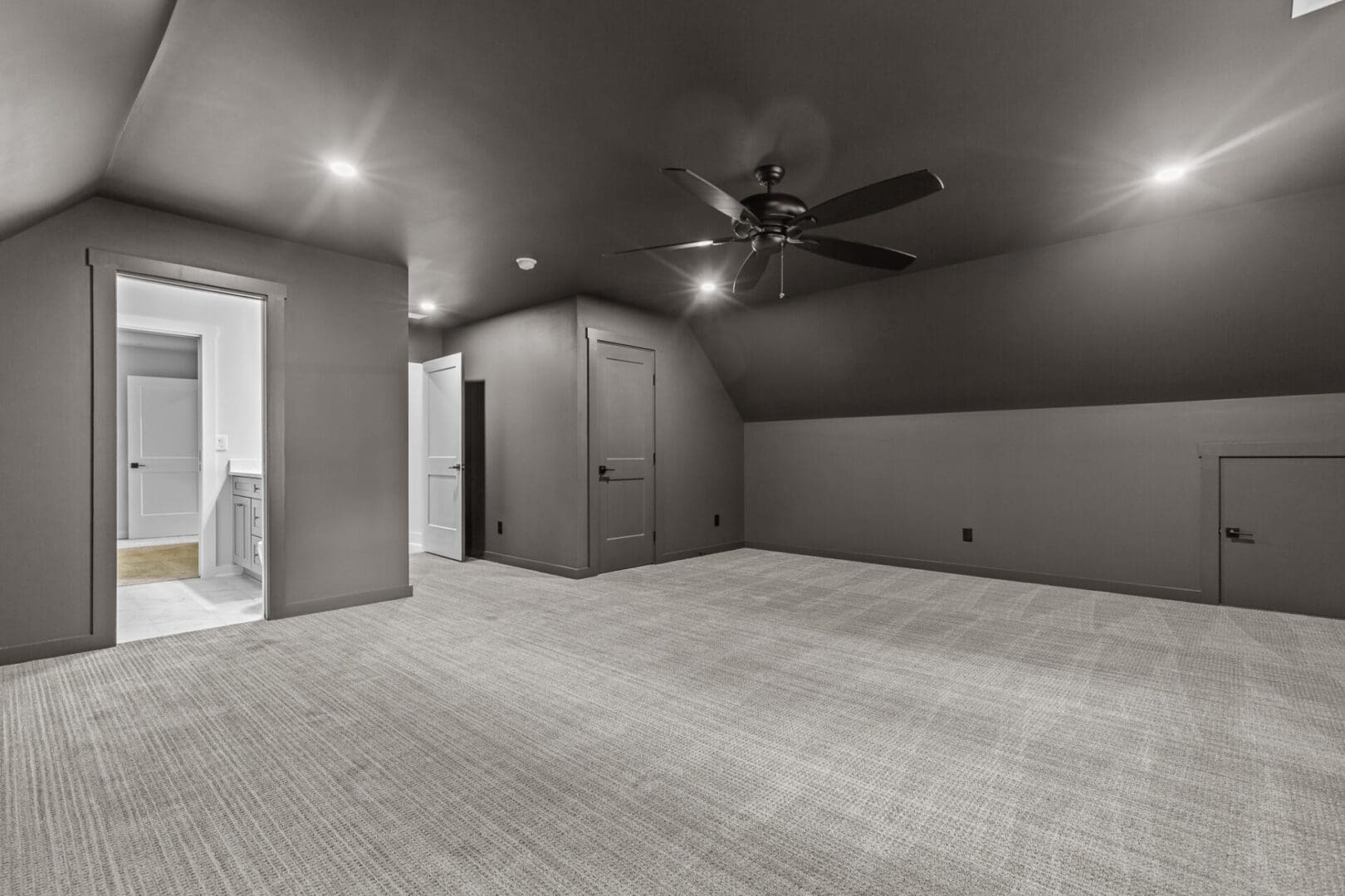 Empty room with ceiling fan and carpet.