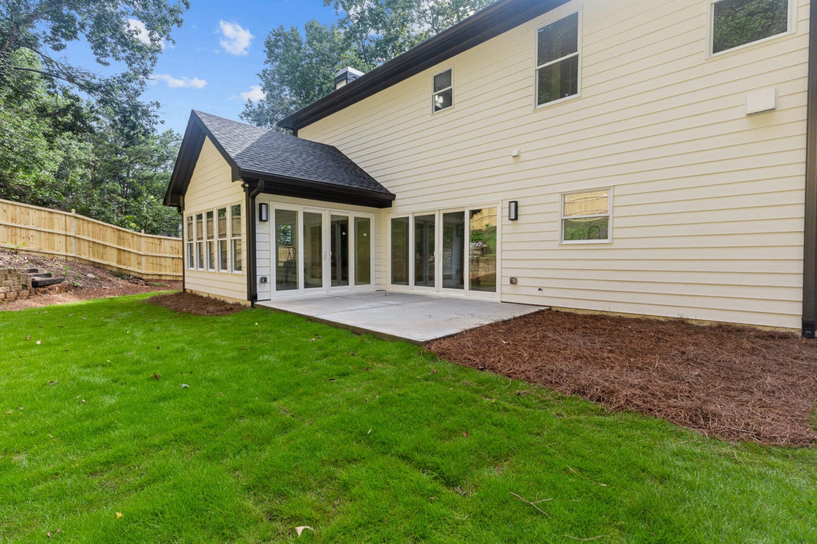 White house with patio and green grass.