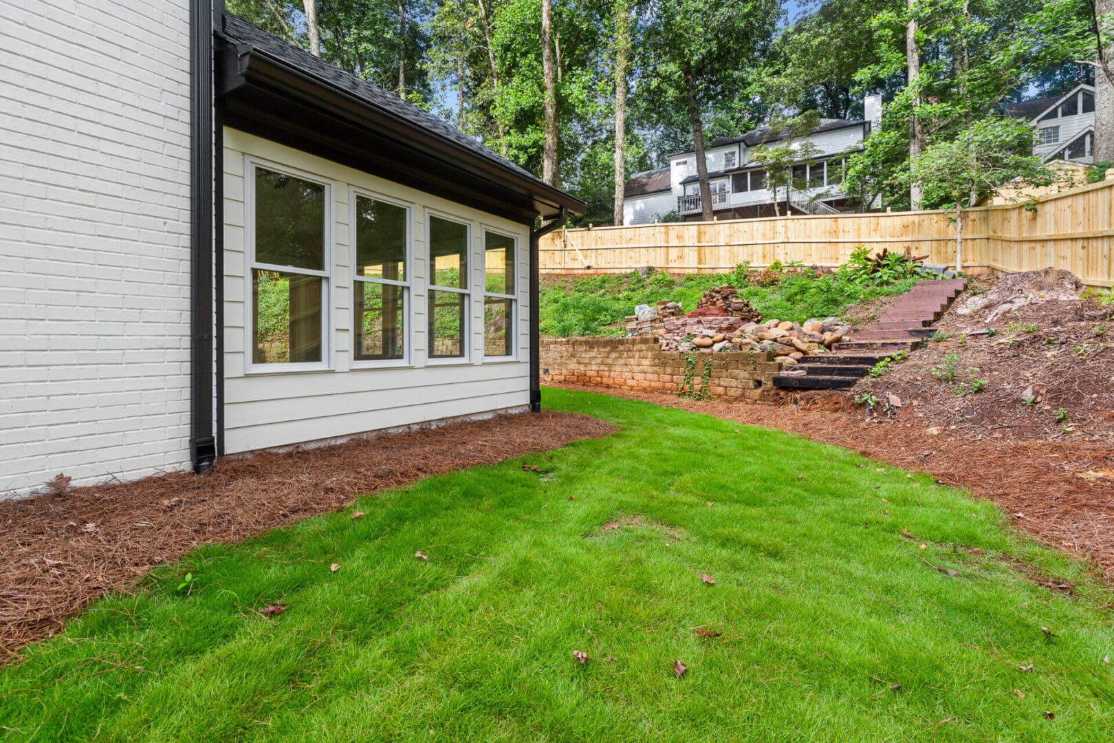 White house with windows and green lawn.