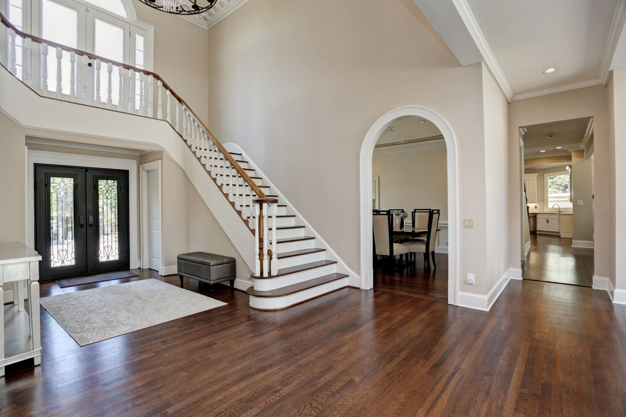 Elegant entryway with staircase and hardwood floors.