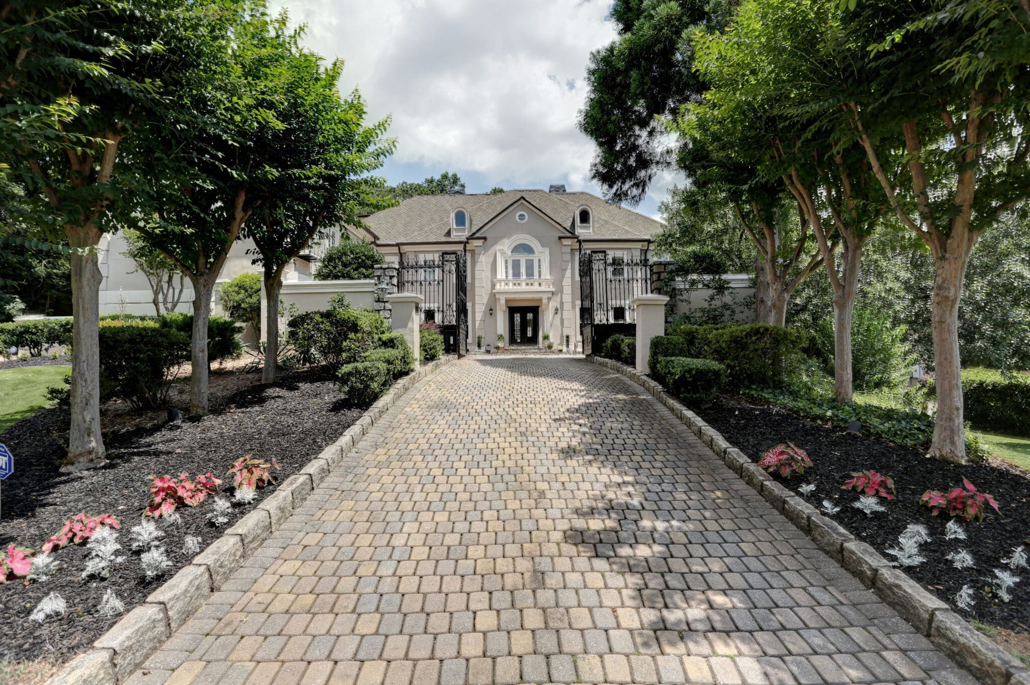 Stone driveway leading to a mansion.