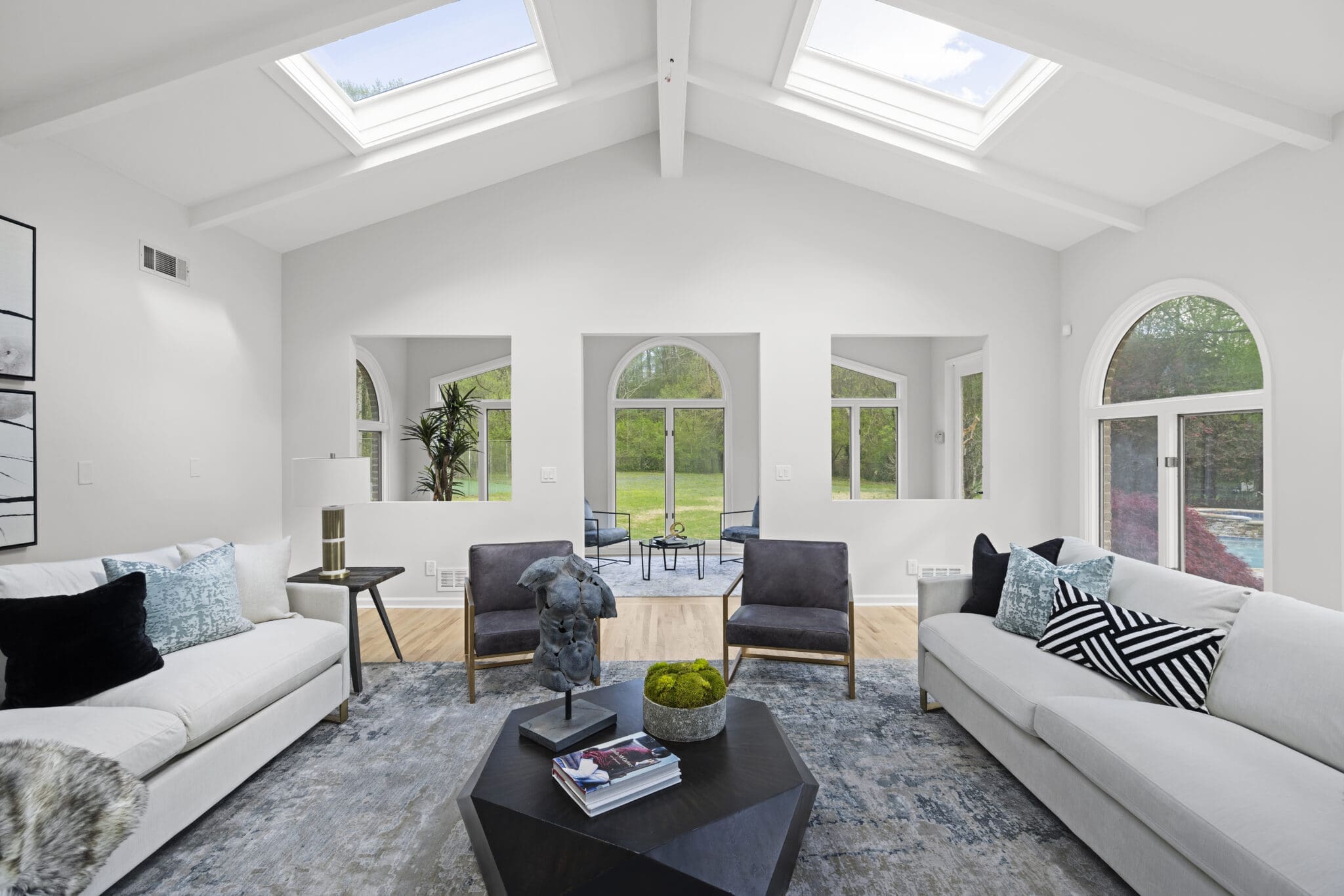 White living room with skylights and large windows.
