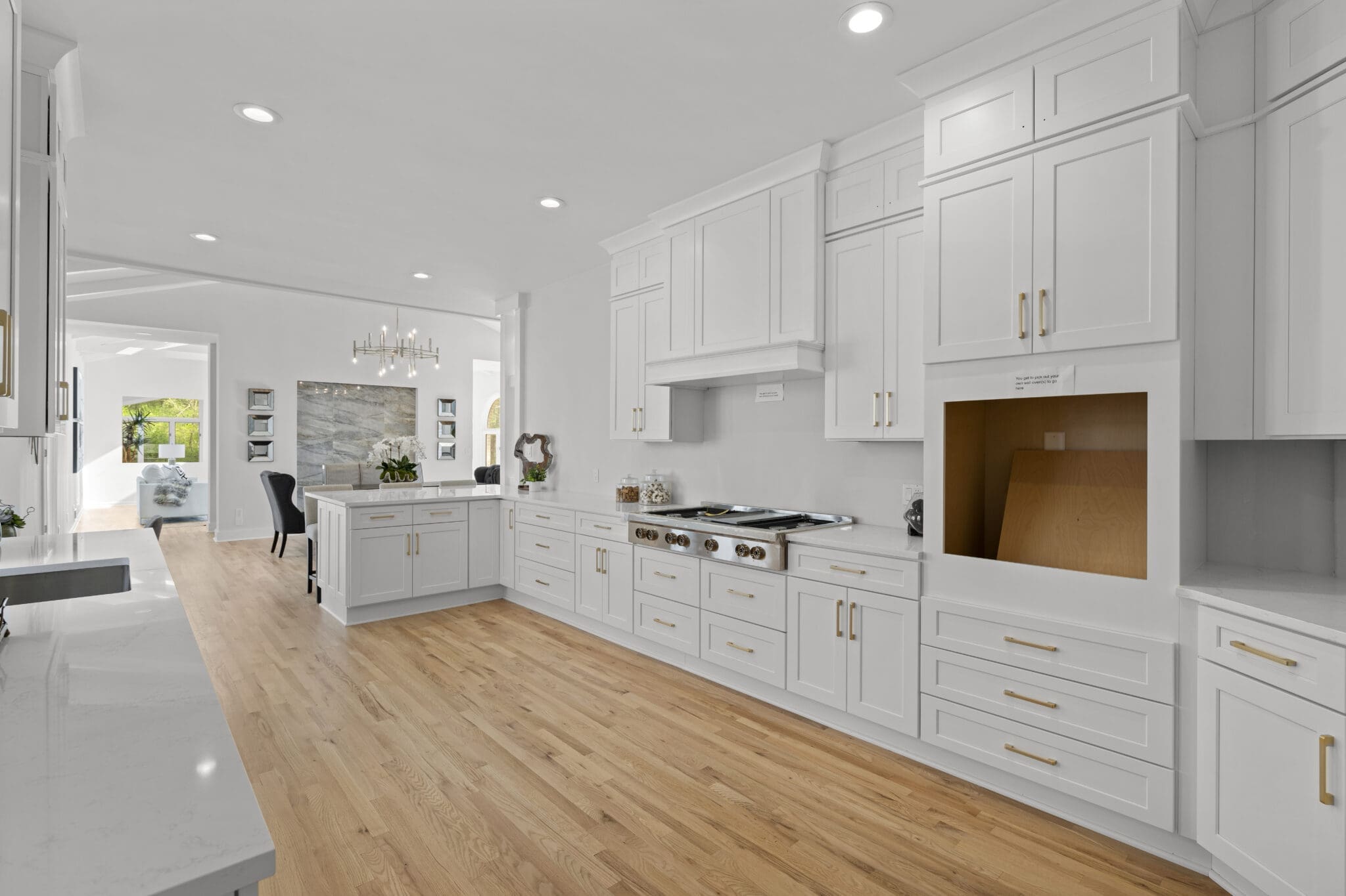 White kitchen with wood floors and cabinets.