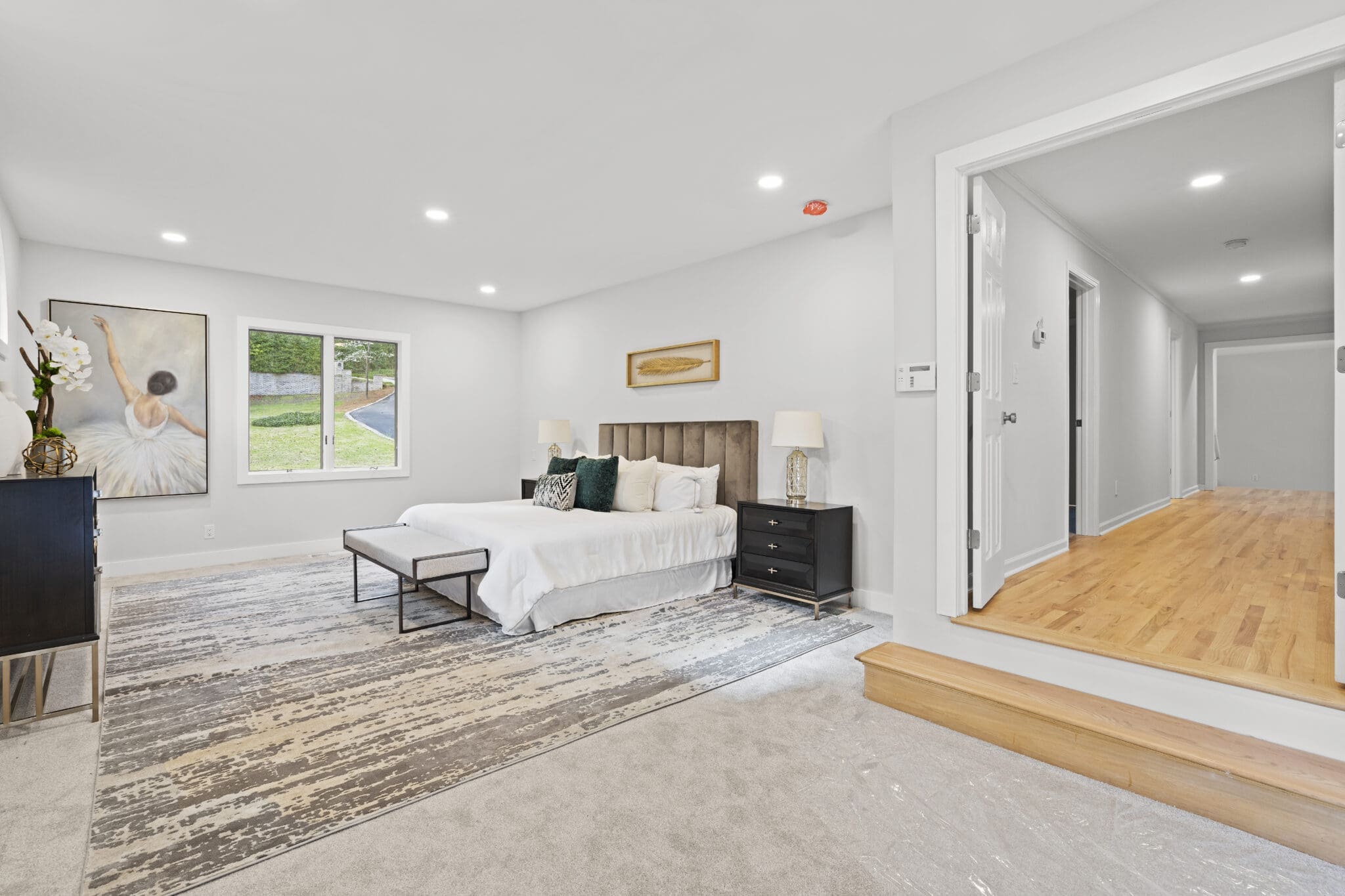 Modern bedroom with large bed and rug.