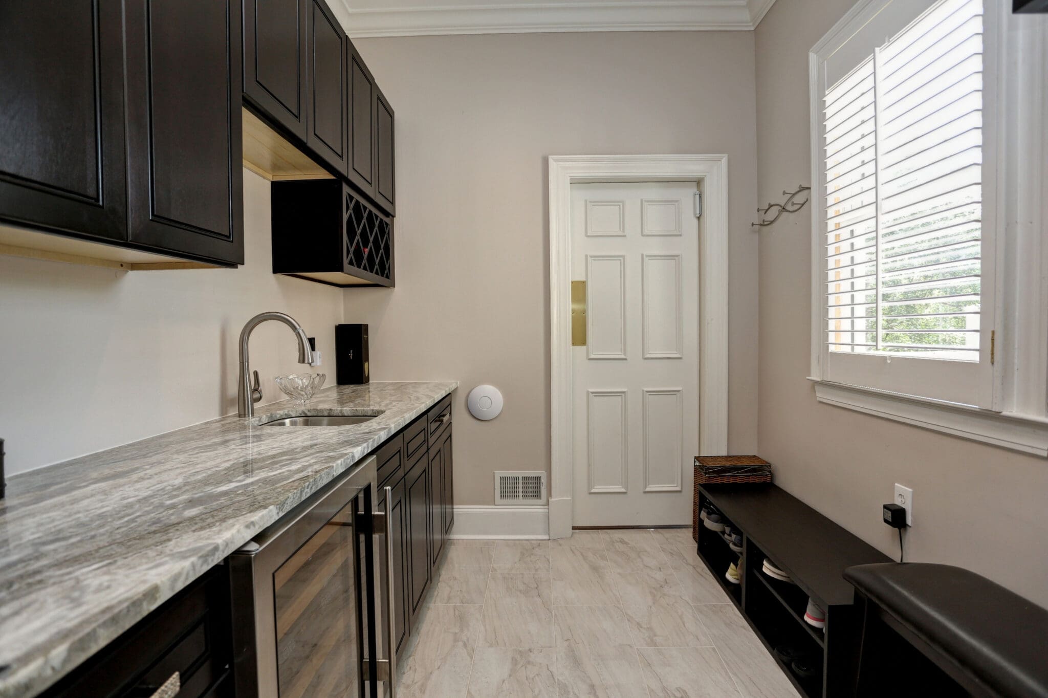 Kitchenette with granite countertop and dark cabinets.