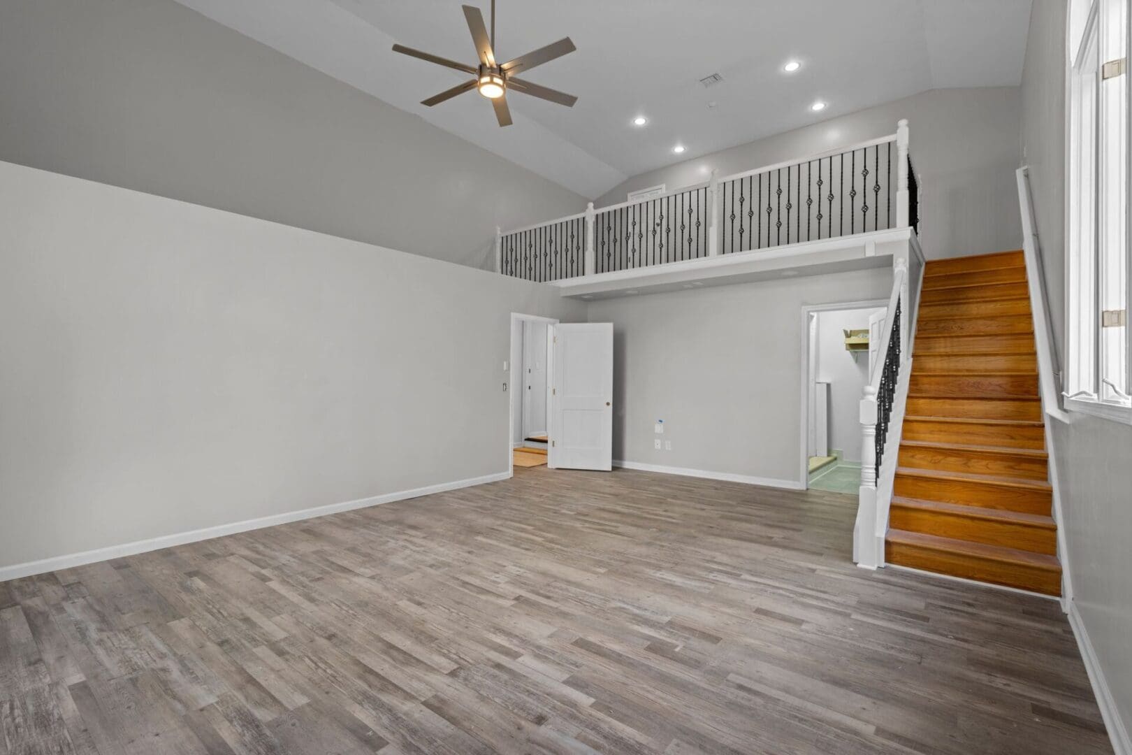 Empty room with wooden stairs and railing.